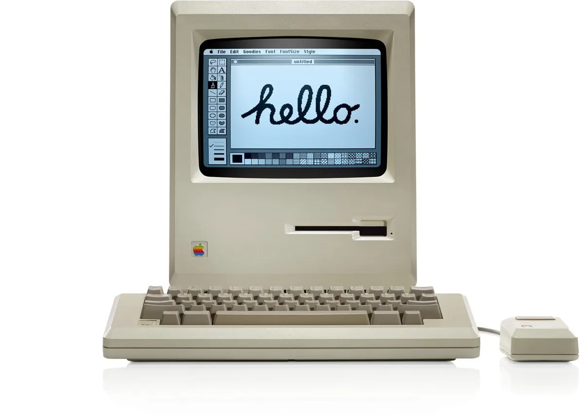 The original Macintosh displaying "Hello" in handwritten font on its 9-inch monochrome screen, January 24 1984