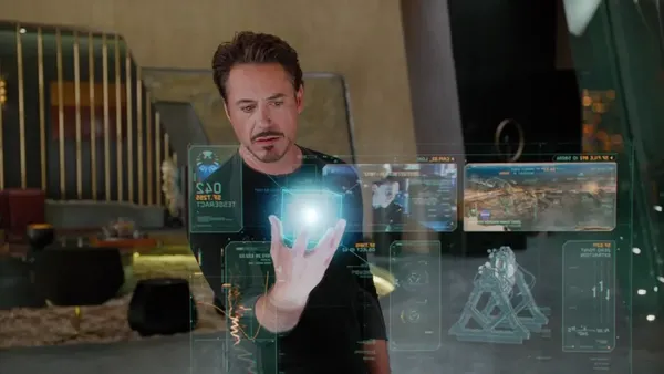 Tony Stark in his workshop, talking to JARVIS surrounded by holographic displays
